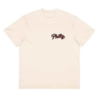 We Talking About Practice tee in natural cream — front view with Philly script logo